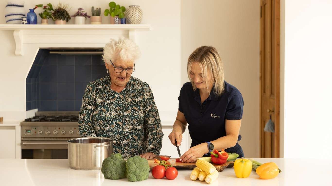 A carer helping to prepare a healthy meal with a client.
