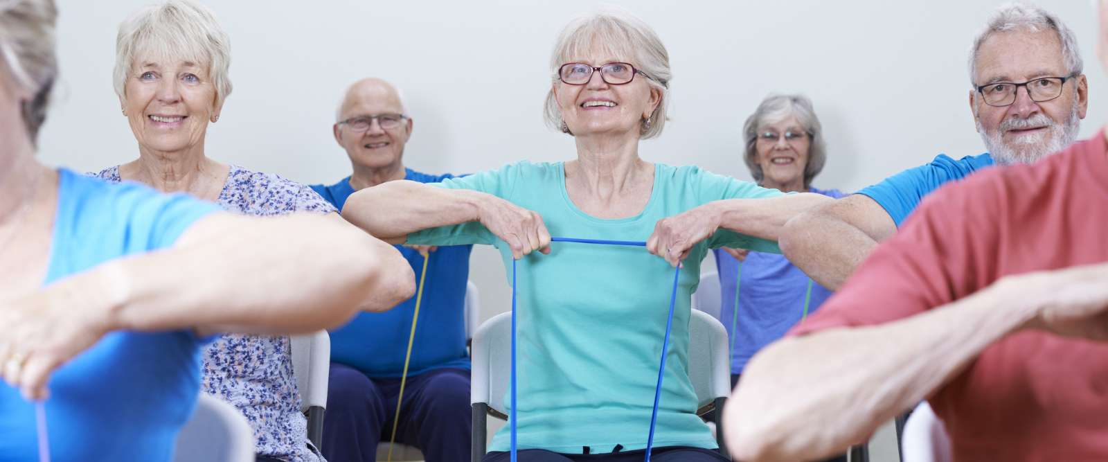 People doing exercise for healthy living with Resistance Bands In a Fitness Class