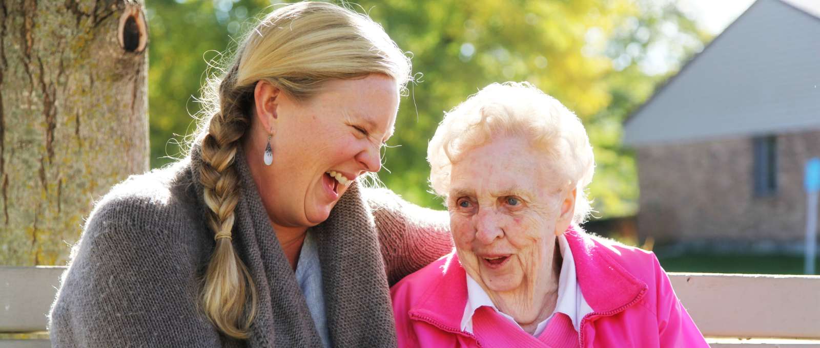 An elder woman with her Carer, laughing together.
