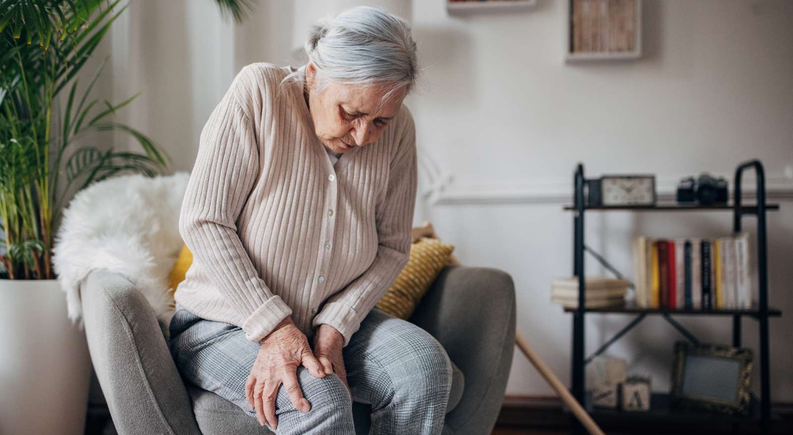 Elderly woman experiencing knee pain from arthritis