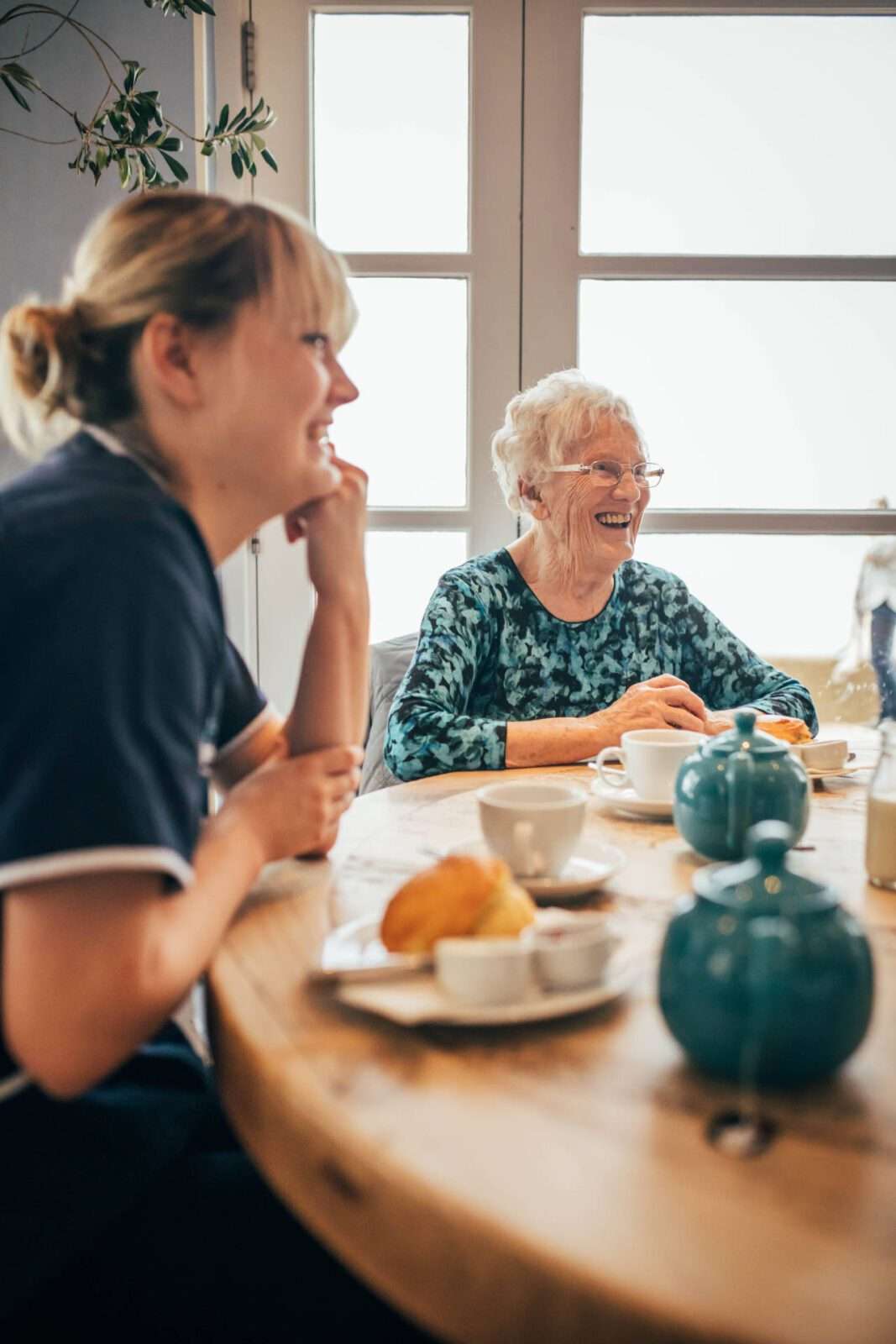 At home care, client and carer having tea and cake.
