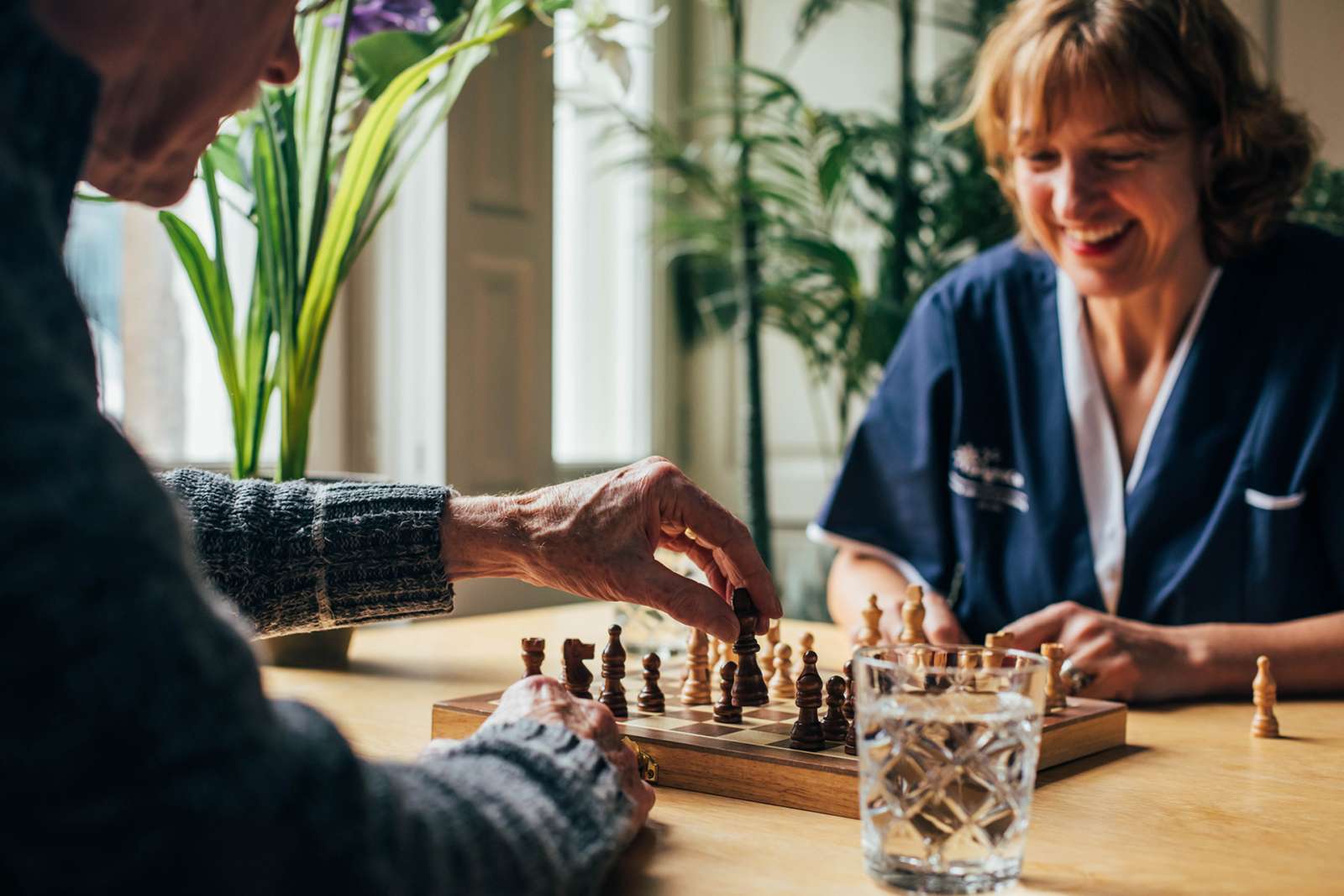Happy at home carer playing chess