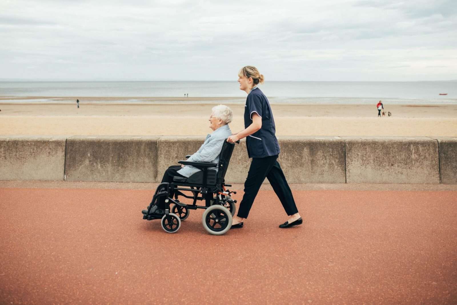 Bright Carer and her client on wheelchair on the promenade