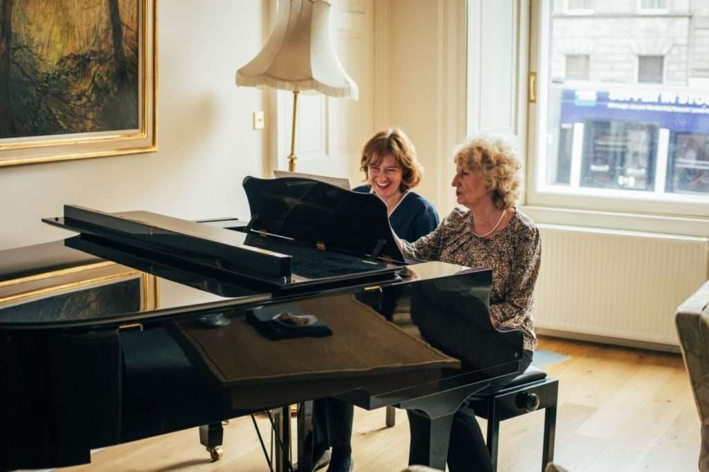 Bright Carer and client playing piano (3)