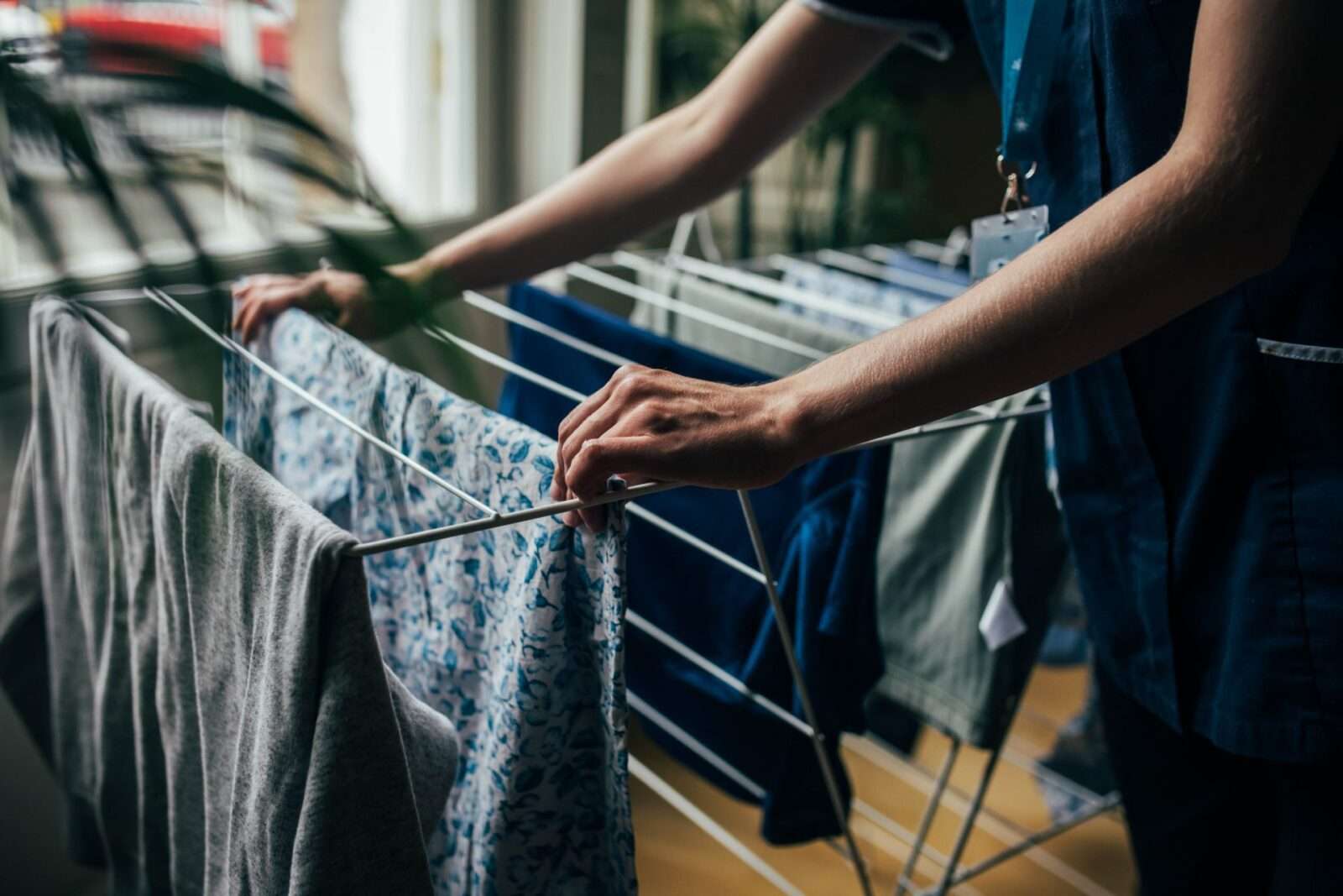 Bright Carer hanging her client's clothes