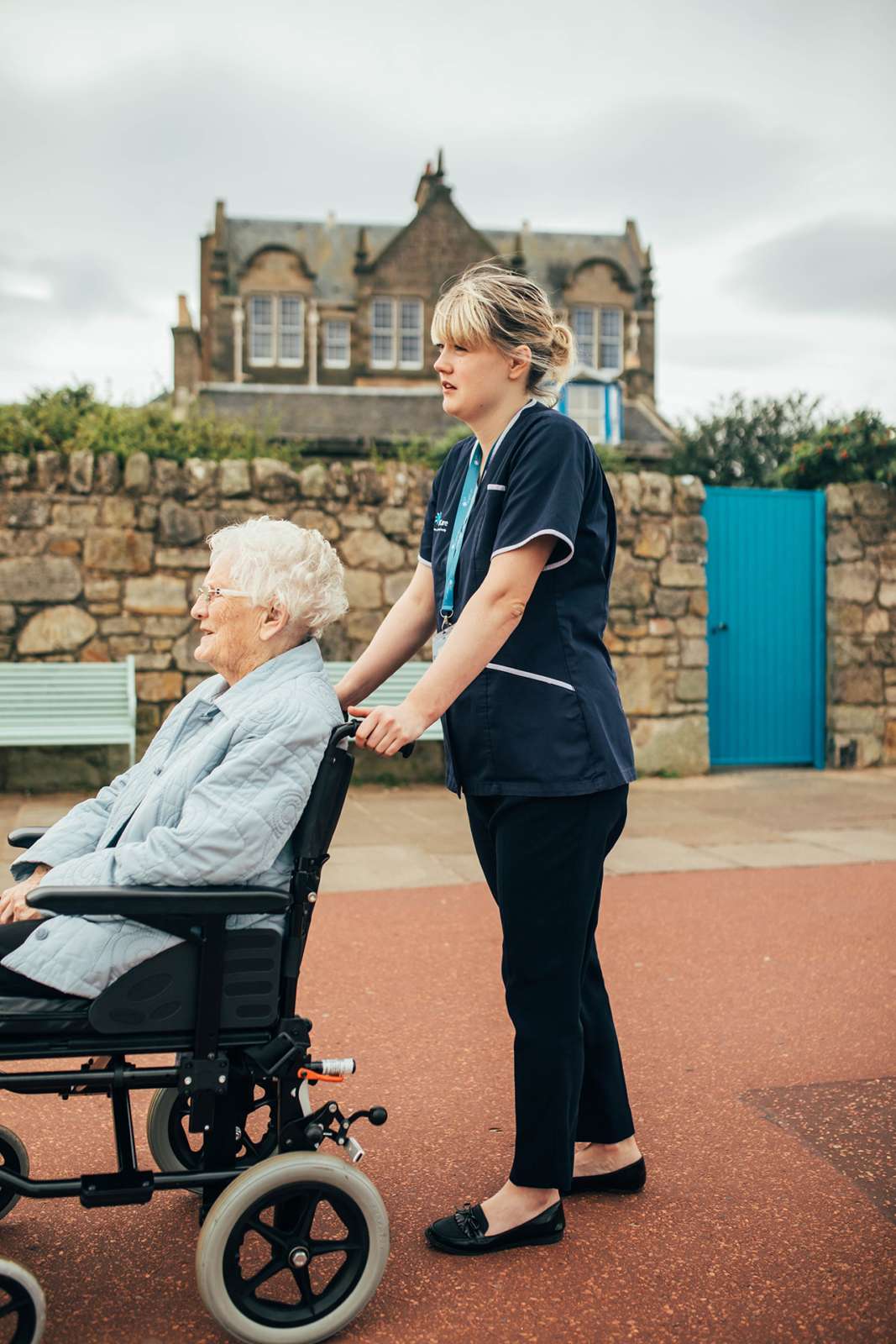 Carer pushing client in wheelchair