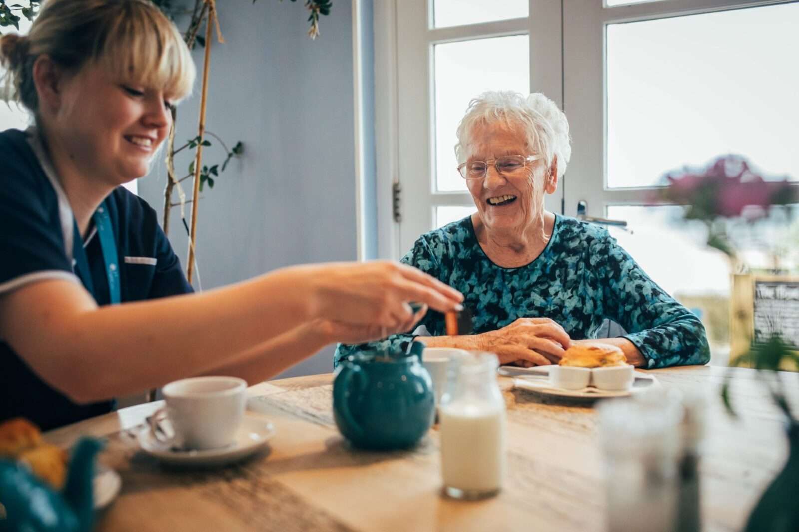 Bright Carer and her client enjoying tea and scones at a cafe