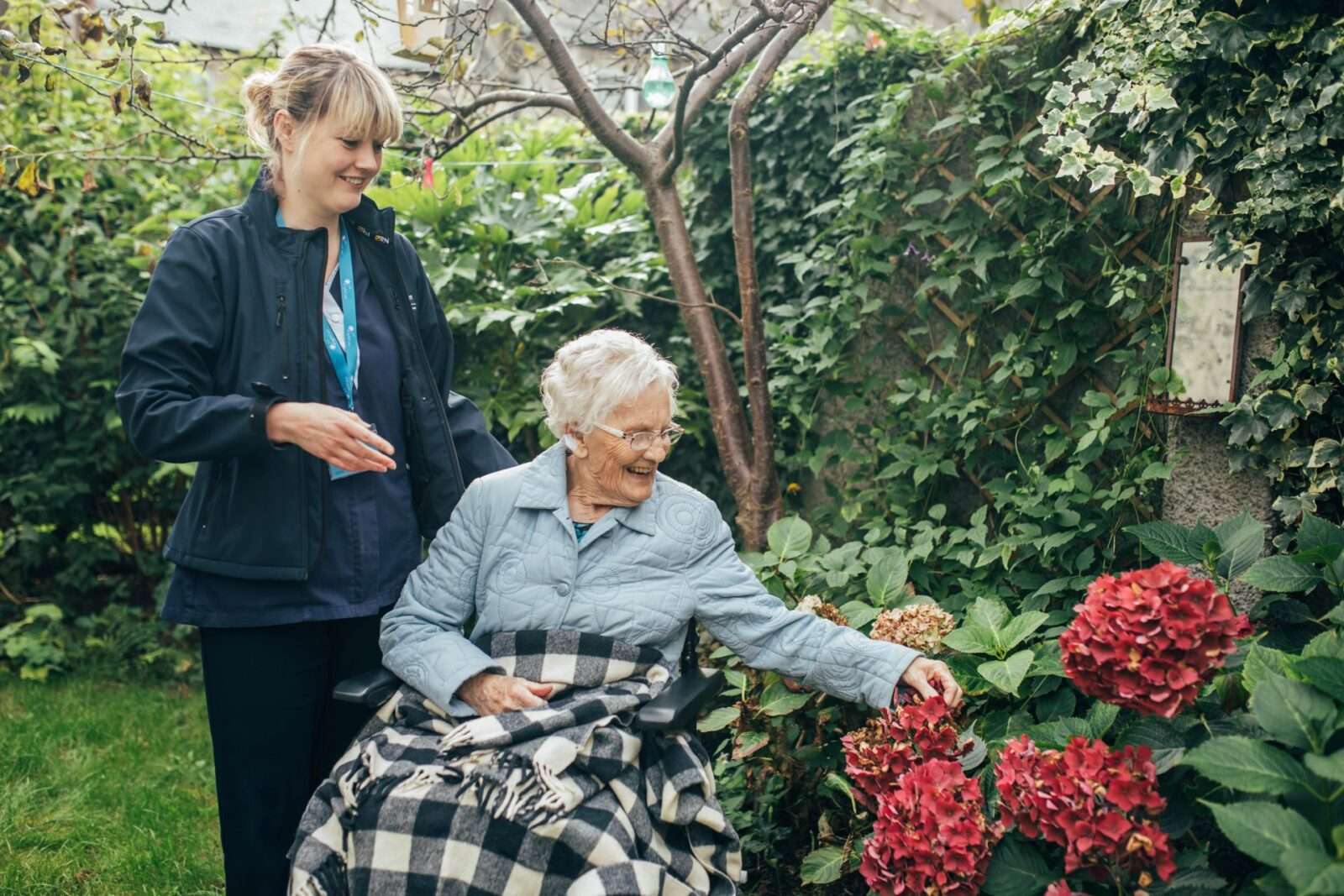 Bright Carer and her client on wheelchair in the garden
