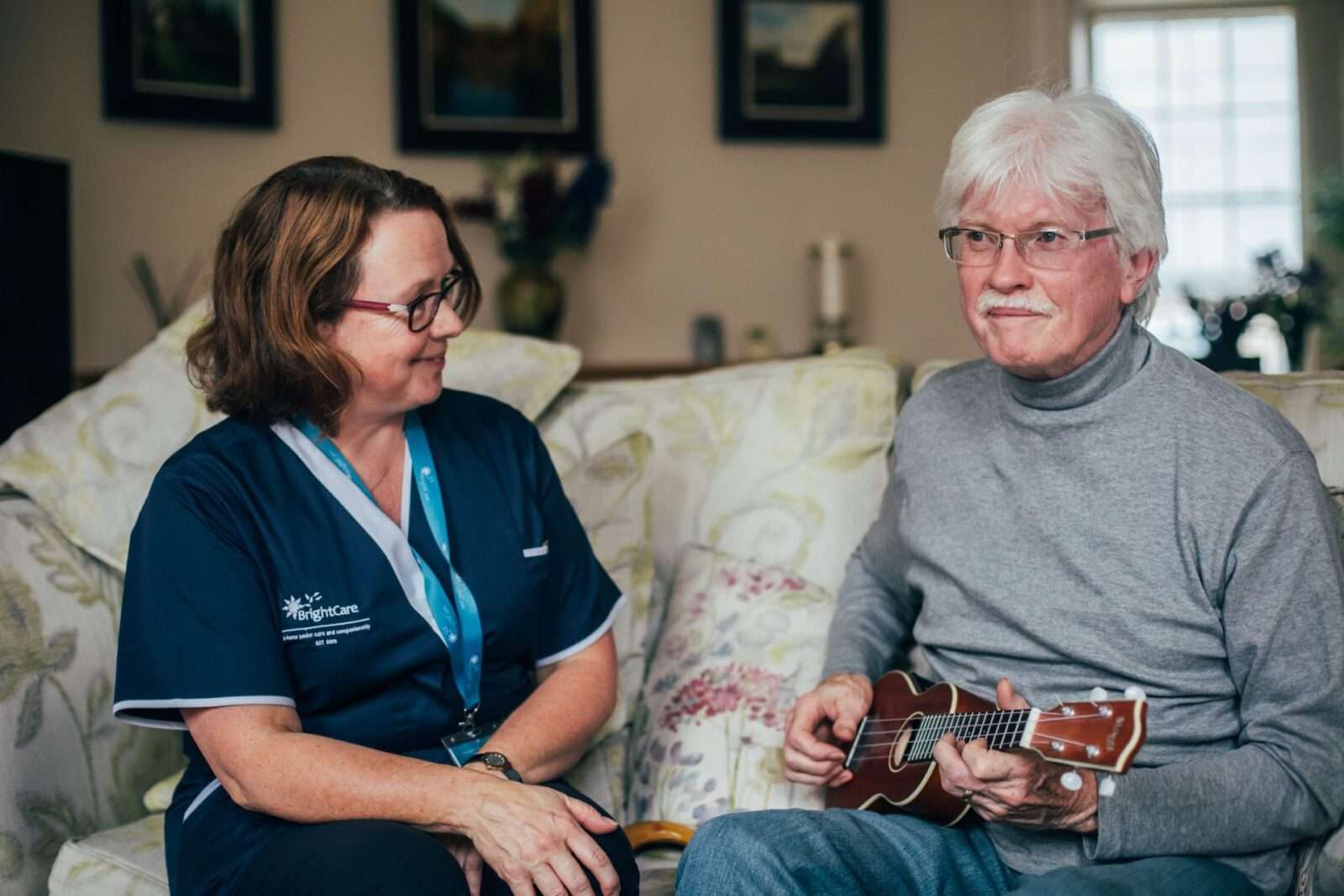 Bright Carer listening to her client that plays ukulele