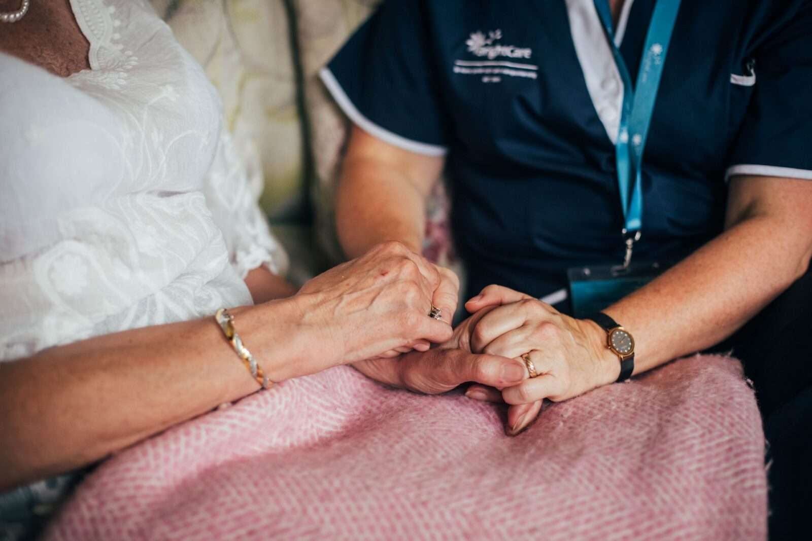 Bright Carer and her client hands in hands