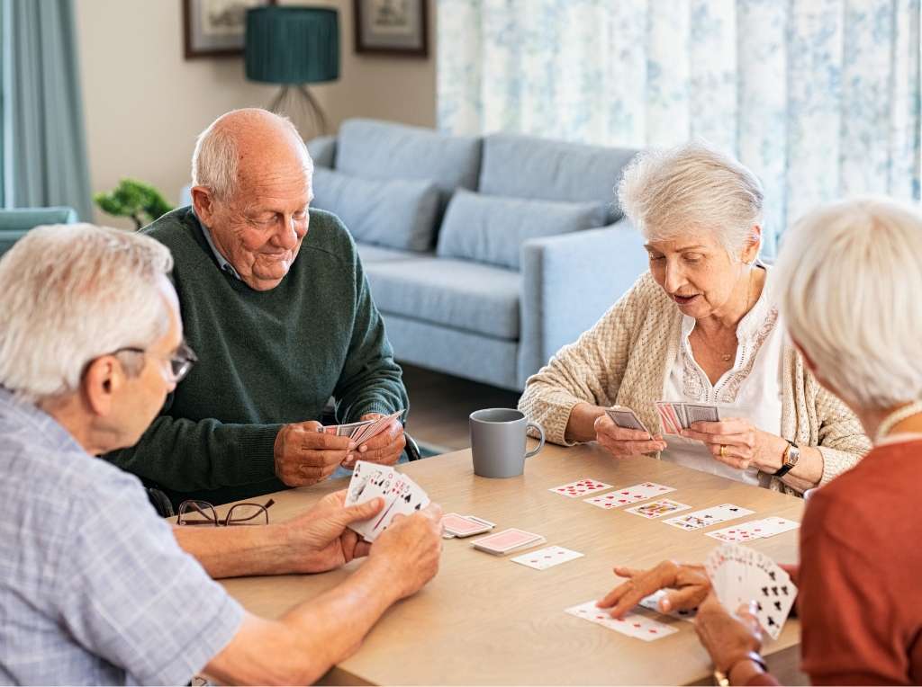 A group of elderly persons enjoying a game of cards.