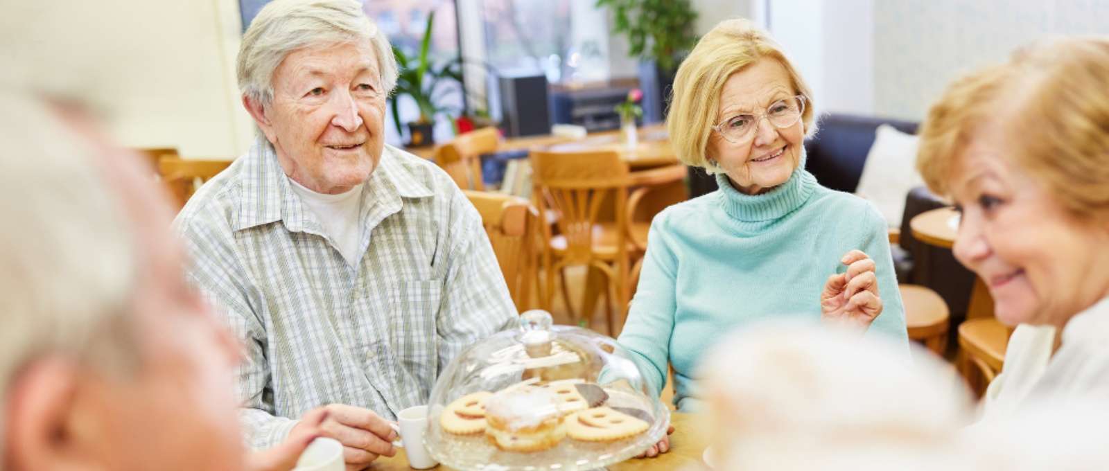 A group of elderly persons enjoying a game of cards.