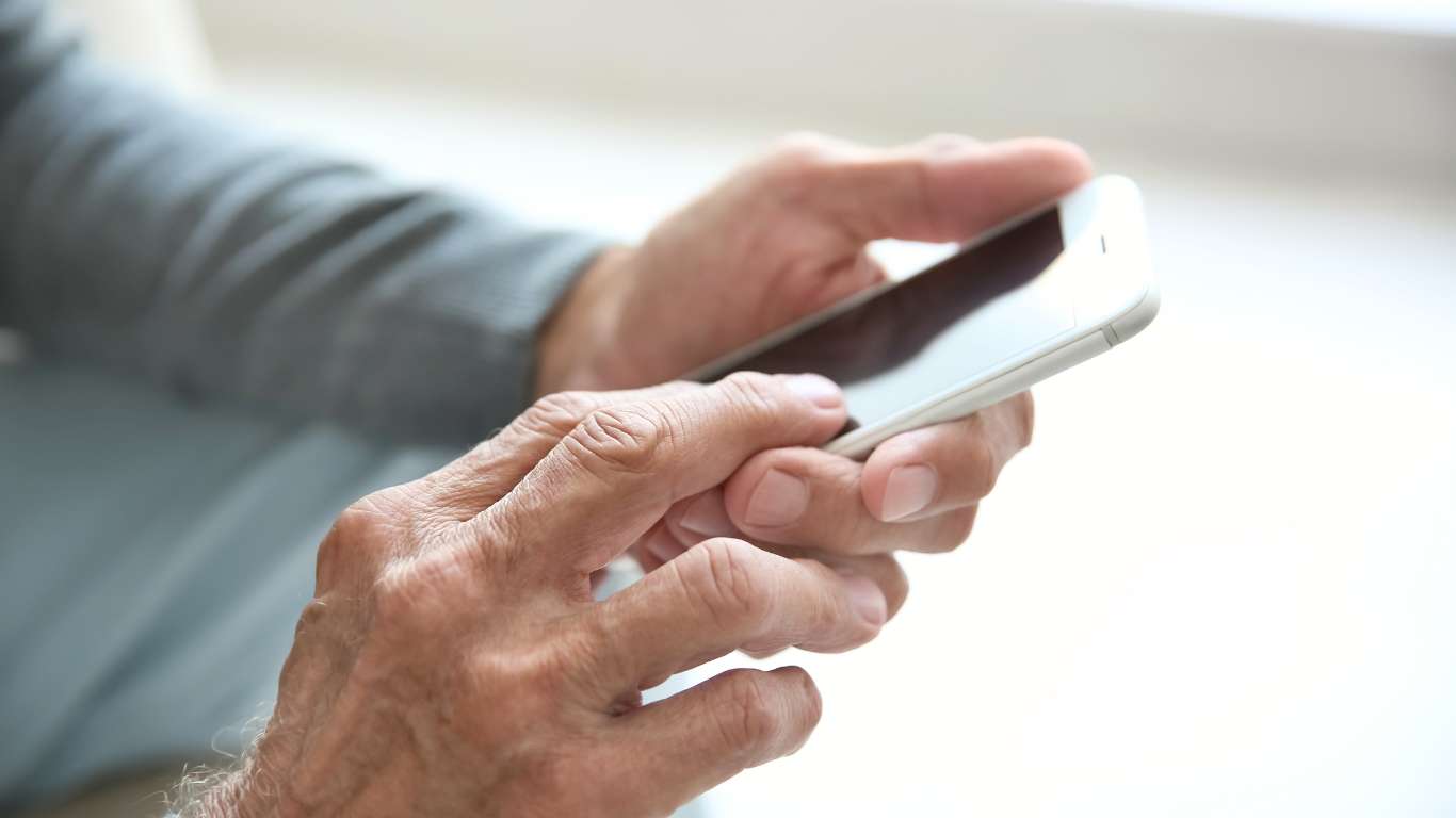 An elderly person using their mobile phone.